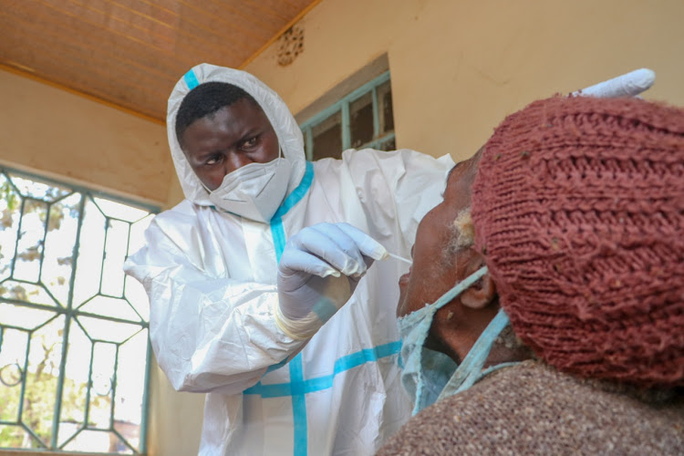 Lab technologist Edwin Sumba collects mouth swab for COVID-19 testing at Kasarani Health Centre on Saturday 17, October