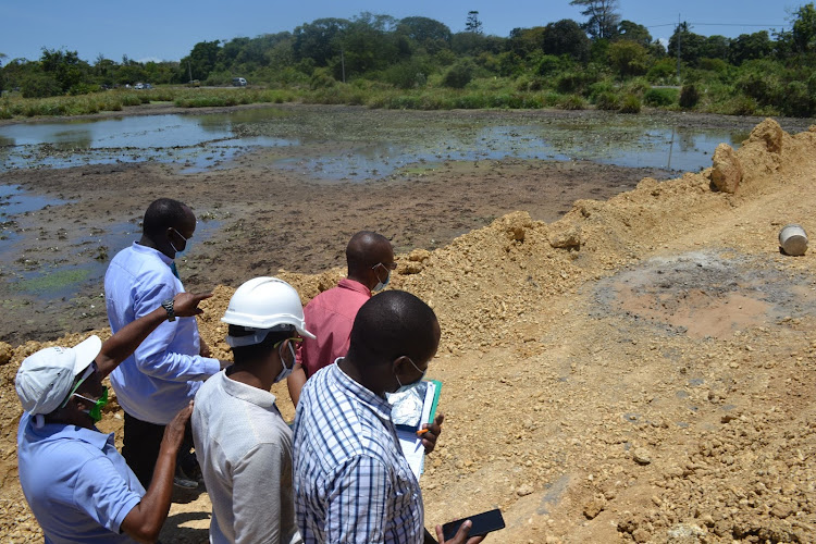 Members of Nema board at the backfilled section of the Kwa Kadzengo swamp in Kilifi on Tuesday.