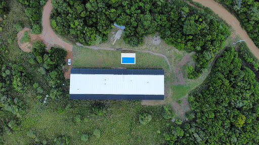 White building with swimming pool and greenery in this luxury farmhouse for sale in Pan de Azucar ($1,590,000)