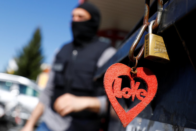 German police, which also involved Germany's GSG9 special operations police unit, walks past a locked rubbish bin outside a building as they raid sites across the country, in a crackdown on human trafficking and forced prostitution in Maintal, south of Frankfurt, Germany, April 18, 2018.