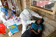 Health workers collect swab samples during free mass testing for the coronavirus disease (Covid-19) in Kibera slums of Nairobi, Kenya.