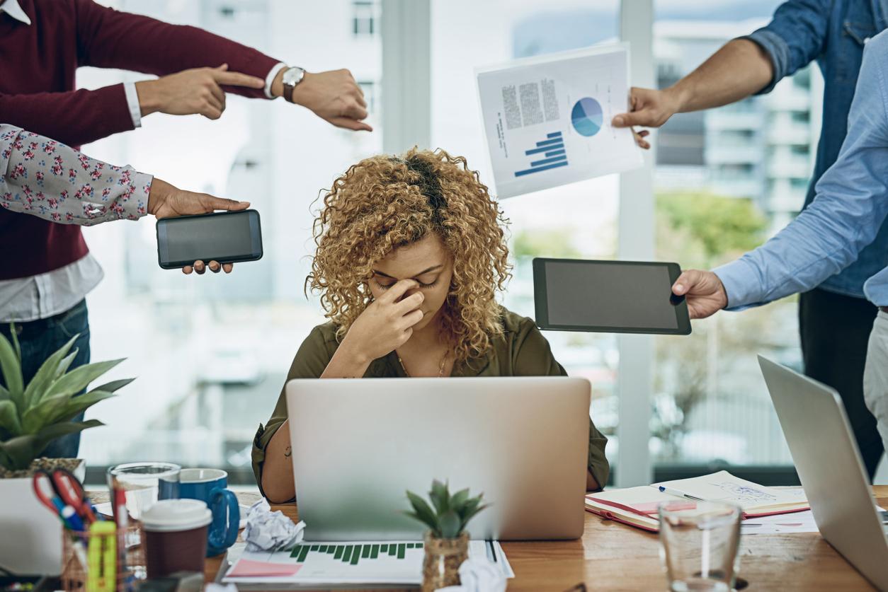 Mulher sobrecarregada por tarefas no trabalho - criando um ambiente de escritório indistristrível