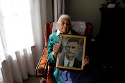 Violet Smith, who is turning 100 years old on May 29, 2019, poses for a portrait in Johannesburg. She is holding a framed picture of her late father William Harper. 