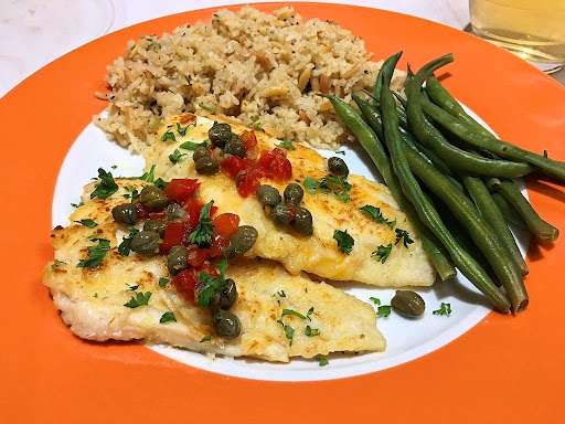 A couple perfectly cooked fillets of haddock topped with a nice lemon-caper-pimiento sauce.