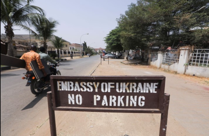People on a motorbike drive past the Ukrainian embassy in Abuja, Nigeria February 25, 2022.