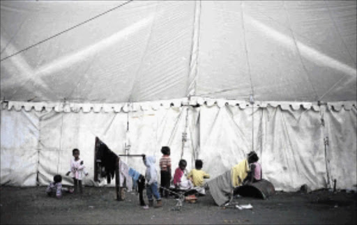 TOUGH LIFE: Children of refugees play in a camp in Chatsworth, Durban. Some of the children were born in South Africa and, according to Home Affairs, that does not guarantee them automatic citizenship Photo: TEBOGO LETSIE