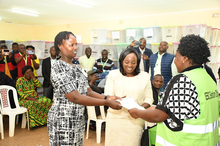 Oscar Sudi's wives collecting his certificate after winning.