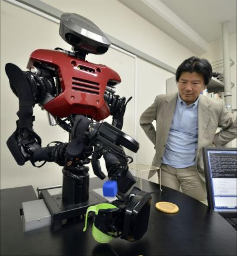 Kawada Industries' humanoid robot Hiro drops a mock ice cube into a cup