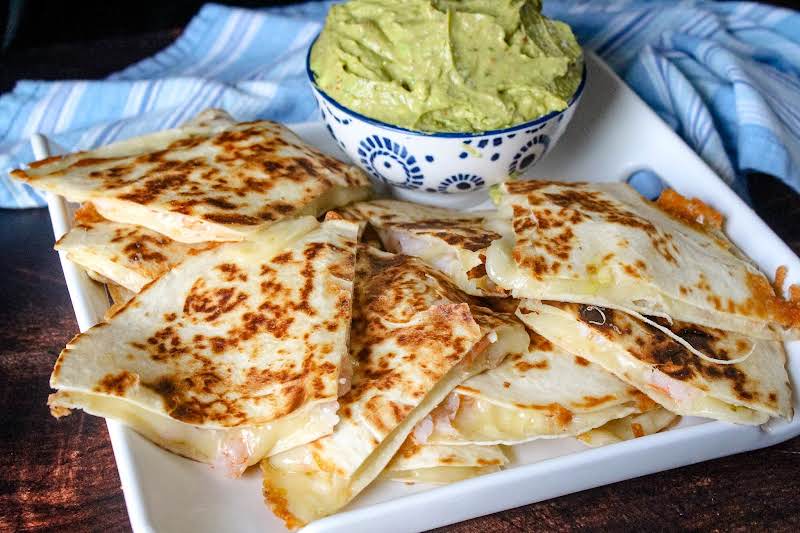 A Plate Of Lime Shrimp Quesadillas With Adobo Guacamole.