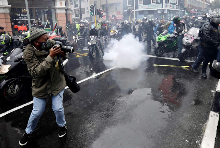 A grenade explodes in the midst of protesting women and motorcyclists near parliament in Cape Town on August 29 2020.