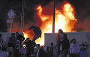 Crowds set Cairo stadium on fire in reaction to the cancellation of a soccer match last night. The referee called off the game after reports of violence at another match in Port Said, where at least 73 people were killed Picture: REUTERS