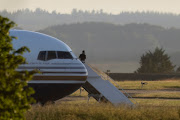 A man stands on the steps of the grounded Rwanda deportation flight EC-LZO Boeing 767 at Boscombe Down Air Base, on June 14, 2022 in Boscombe Down near Amesbury, Wiltshire, England.