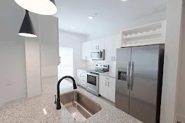 Galley style kitchen with a window, stainless steel appliances, granite countertops, and matte black hardware