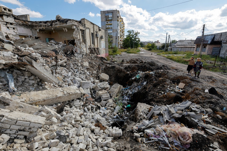 Local residents stand next to the debris of a destroyed building in the course of Russia-Ukraine conflict in Lysychansk, the city controlled by pro-Russian troops in the Luhansk region, Ukraine September 21, 2022.