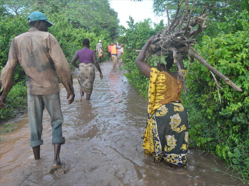 Residents of Wema village in Tana River wade through fl oods on Monday /ALPHONCE GARI