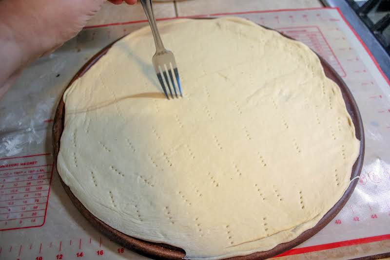 Pricking Rolled Out Dough With A Fork.