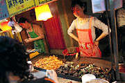 Cooks prepare street food in China. 