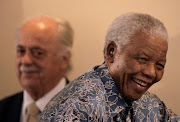 Former president Nelson Mandela walks past George Bizos, his lifelong friend, as he leaves a media briefing after his acceptance of historical collections from the National Archives at the Mandela Foundation in Houghton, Johannesburg, on November 28 2008.