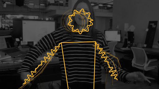 Black and white web camera feed of woman  raising arms slightly. Yellow lines are mapped over the her body and lines are squiggly, to indicate movement and sound.