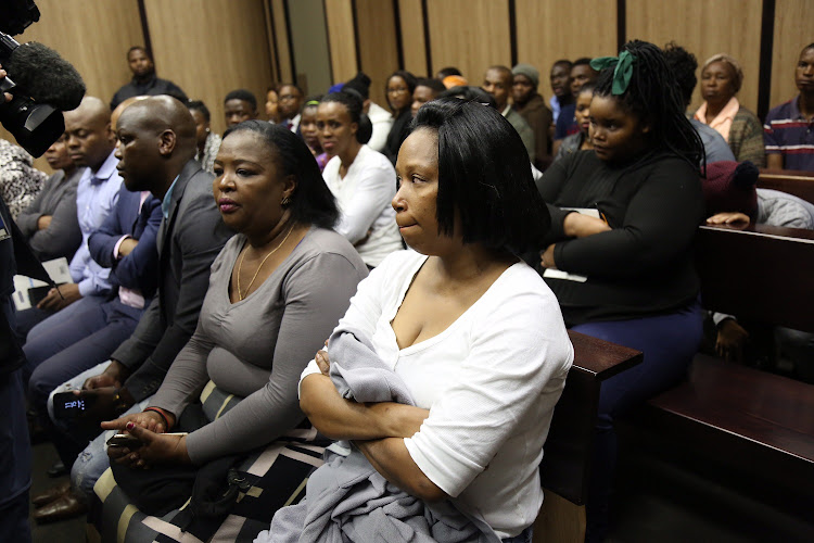 Happy Dube (in white) the mothers of Lindokuhle Dube watches as her son faces assault charges in the Ntuzuma court.