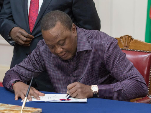 President Uhuru Kenyatta signs the Appropriation Bill 2018 into law at State House on Friday, June 29. /PSCU