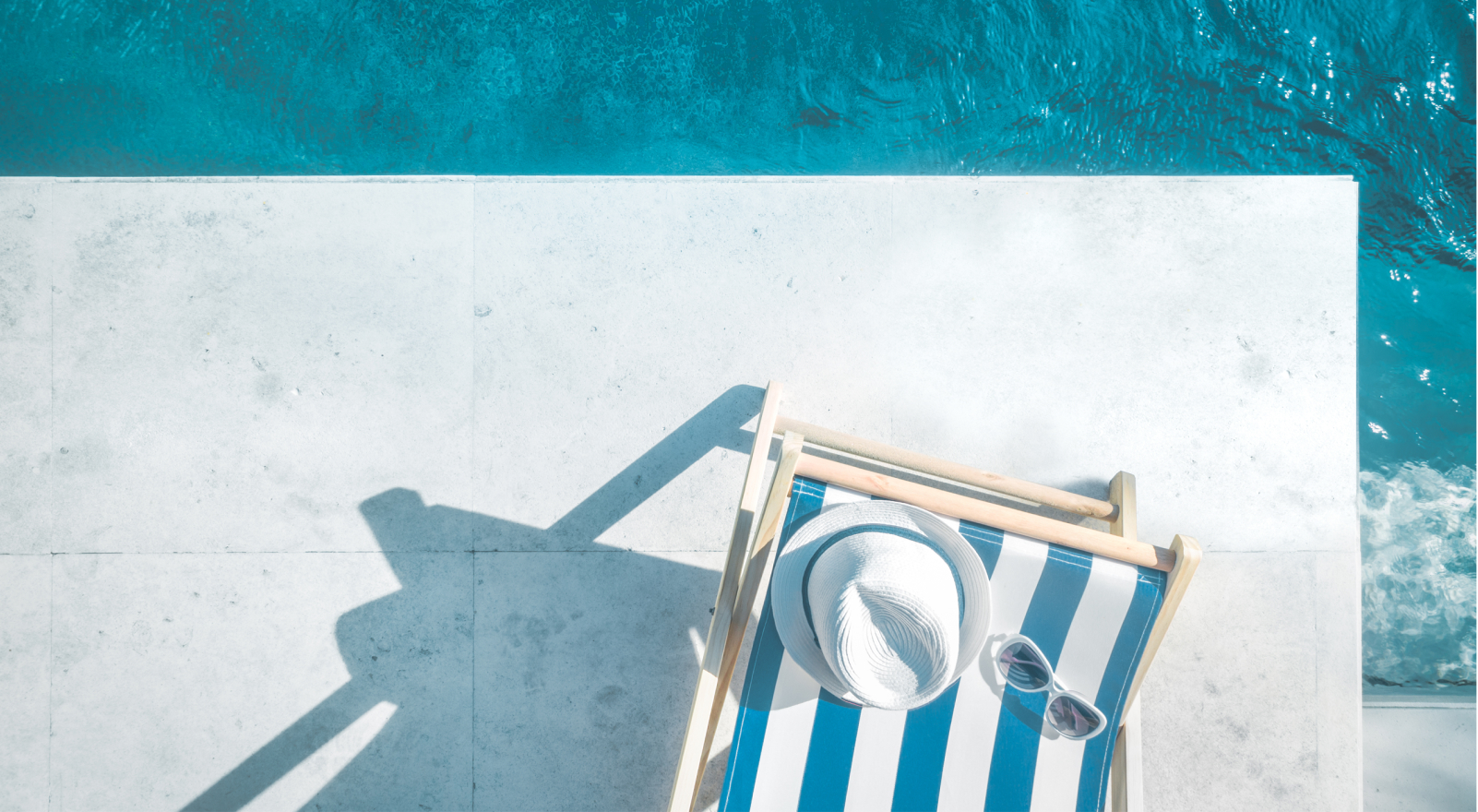 Poolside of a hotel with a striped lounge chair