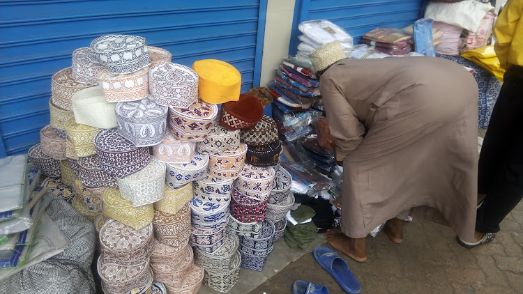 A trader sells Muslim hats, robes and praying mats in Mombasa