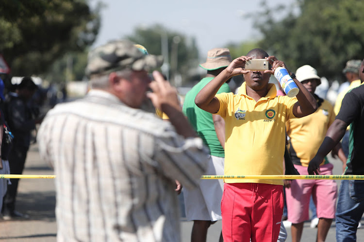 Members of the farming community and protesters take video footage of one another at Hoerskool Overvaal in Vereeniging during protests there