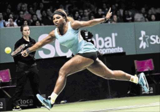 BUSINESS-LIKE: Serena Williams of the US reaches to return a shot to Eugenie Bouchard of Canada during the Women's Tennis Association Finals round-robin match in Singapore yesterday PHOTO: ROSLAN RAHMAN/AFP