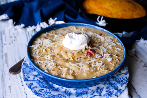 A bowl of After Thanksgiving White Chili with sour cream and mozzarella cheese.