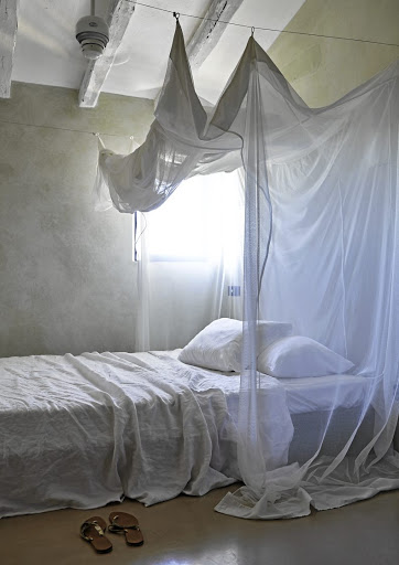 A casually draped fabric canopy above the bed gives this bedroom a dreamy feel.