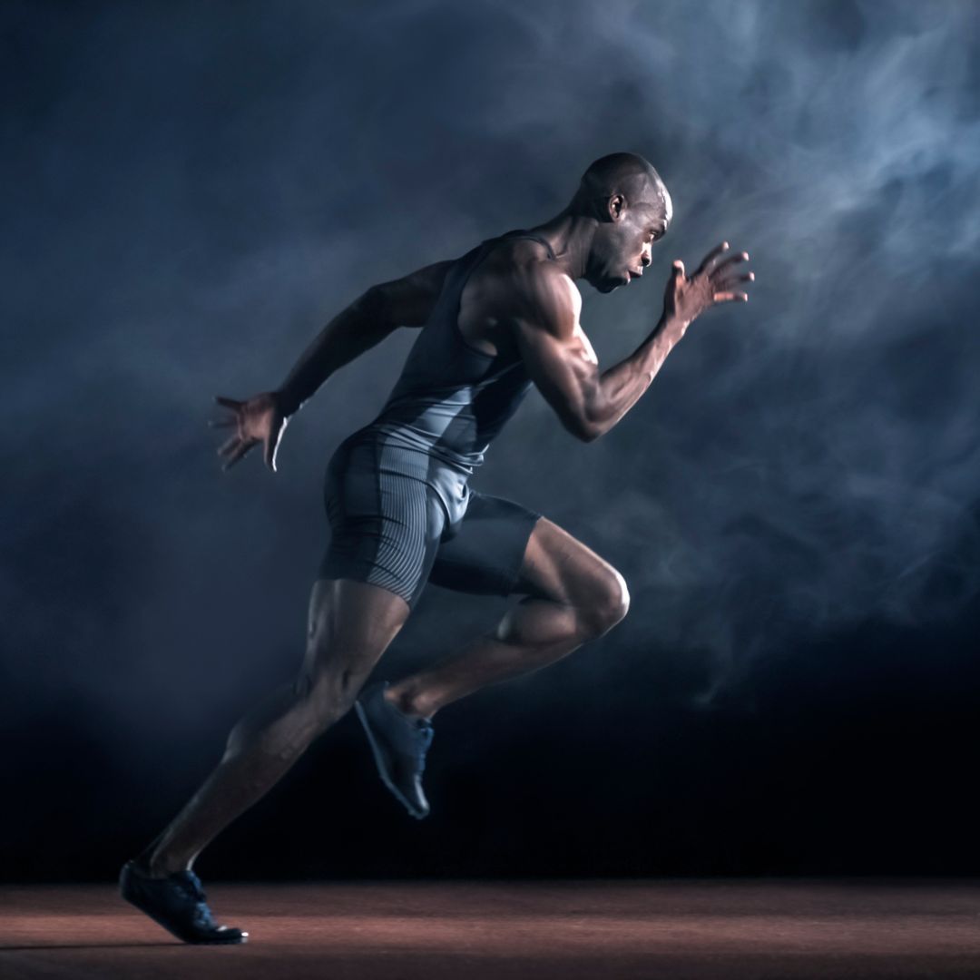 A side view of a man sprinting wearing compression clothing