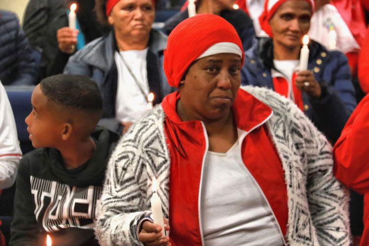 A mother who lost her child to gang violence in Cape Town takes part in a candle vigil as part of the #TotalShutdown march across South Africa on August 1, 2018.