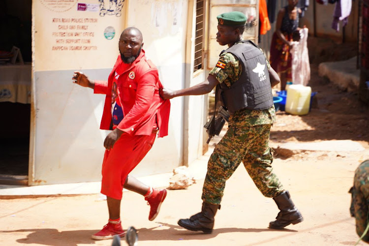 A Uganda police captured arresting a supporter a NUP supporter.