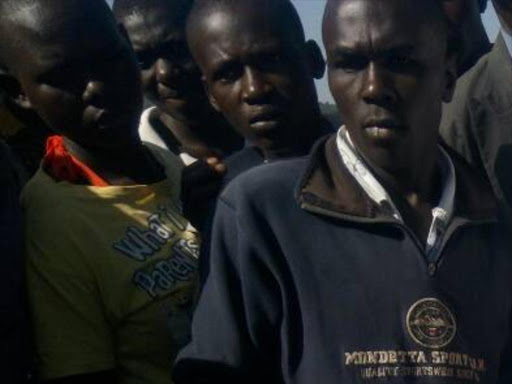 Curious onlookers at the scene where one person was killed following a clash between supporters of Awendo MP Jared K'Opiyo and Walter Owino in the constituency on Sunday, June 25. /MANUEL ODENY