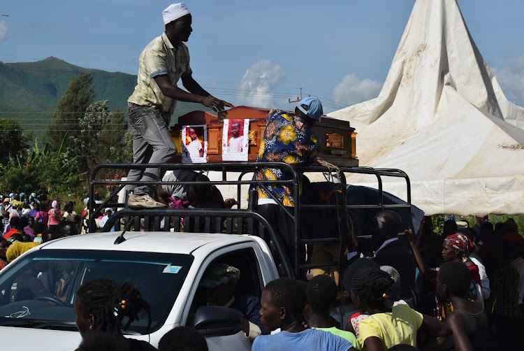 Men fasten caskets of children who died from ravaging floods on a vehicle to ferry for burial in Sindo, Suba South constituency on May 15,2024