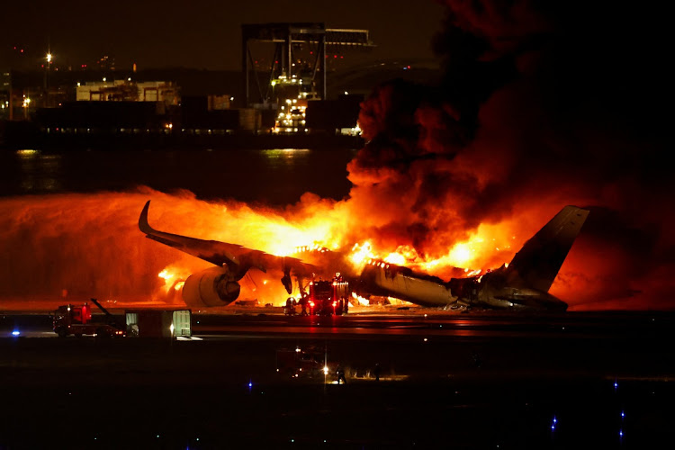 Firefighters work at Haneda International Airport after Japan Airlines' A350 airplane caught on fire in Tokyo, Japan, on January 2 2024.