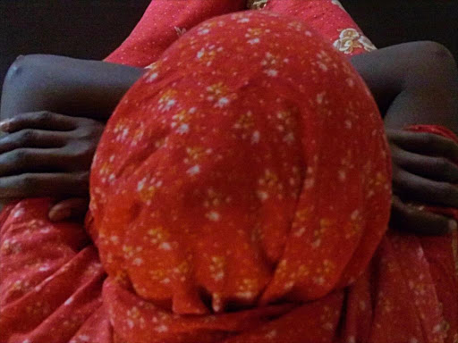 A 20-year-old Somali refugee now living in Kenya, clasps her shoulder as she sits in the Kenyatta National Hospital in Nairobi, where she received treatment for obstetric fistula, in this June 23, 2011. /REUTERS