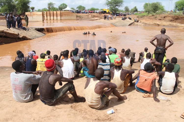 Members of public follow on rescue activities at the scene where a bus plugged into a river killing more than 20 people at River Enziu, Mwingi Central, Kitui on December 5, 2021/ANDREW KASUKU