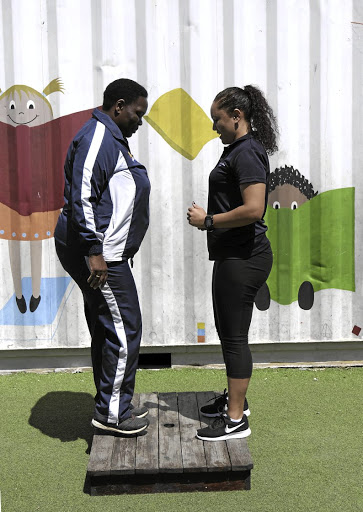 Teacher Nomonde Ntsundwana, left, gets exercise tips from biokineticist Danielle Smith. Ntsundwana, who has dropped 10kg since she joined the KaziHealth programme in May at 110kg, says she now eats smaller portions.