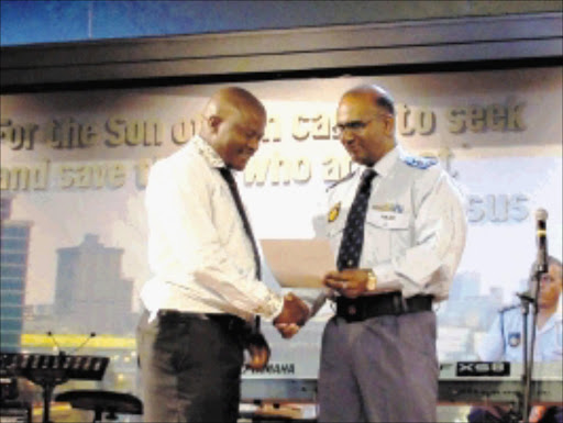 WELL DONE: Sergeant ID Makhedi receives an award for being the top functional member of the police service from Assistant Commissioner Oswald Reddy. Pic: LOUISE MCAULIFFE. 17/03/2010. © Sowetan.