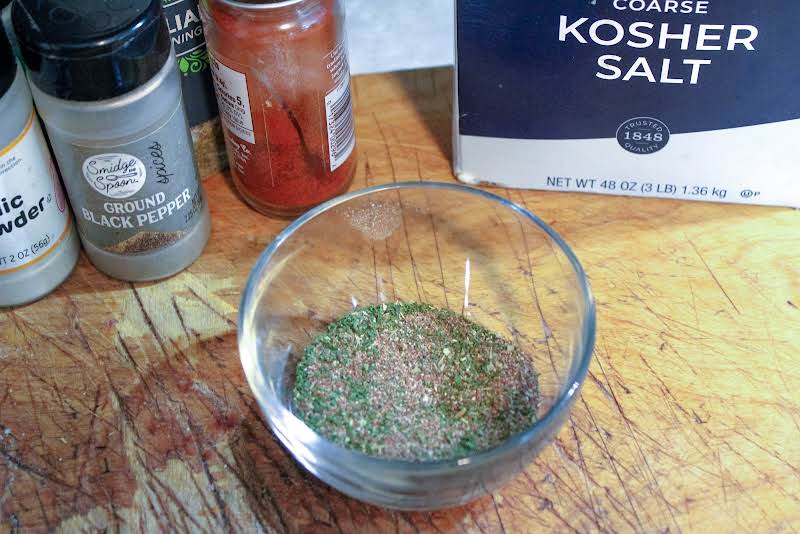 Salt, Pepper, Garlic Powder, Paprika, And Oregano In A Small Bowl.