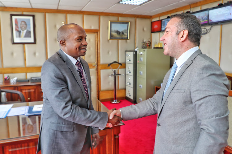 Interior CS Kindike Kithure shaking hands with International Organisation for Migration regional director for East & Horn of Africa, Muhammed Abdiker on Friday, December 9.