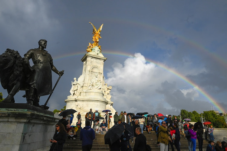 People look towards Buckingham Palace near Queen Victoria memorial as a rainbow forms, following a statement from the Palace that Britain's Queen Elizabeth had died, in London, Britain September 8, 2022. Picture: REUTERS/Toby Melville