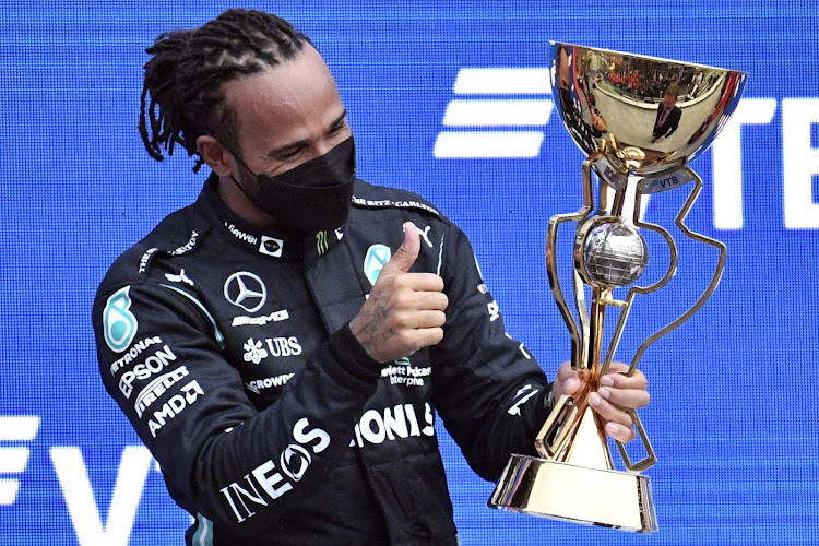 Winner Mercedes' British driver Lewis Hamilton celebrates on the podium after the Formula One Russian Grand Prix at the Sochi Autodrom circuit in Sochi on September 26, 2021.