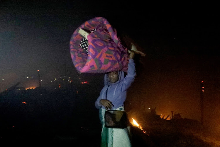 A woman with her luggage at Dakota Informal Settlement in Isipingo.