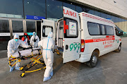 Staff wearing protective suits to protect from Covid-19 load a stretcher into an ambulance outside the main press centre ahead of the 2022 Winter Olympics in Beijing, China, on January 7 2022.    