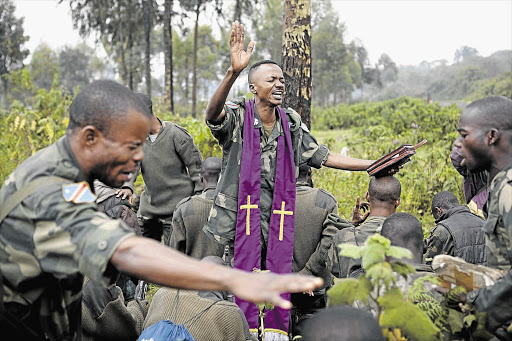 Congolese army chaplain Lieutenant-Colonel Aaron Kubuta prays with Congolese soldiers near the frontline as they try to push M23 rebels out of Goma