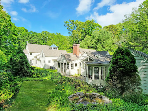 White house surrounded by lush greenery in this luxury property for sale in Ridgefield ($1,399,000)