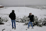 People wear masks as they enjoy the rare opportunity to enjoy a day of heavy snowfall.